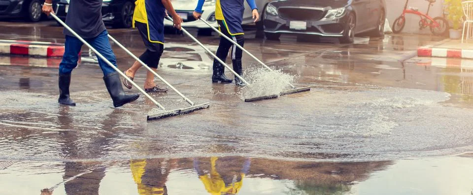 Selective focus to worker using wiper or squeegee to clean floor surface. Stockfoto's