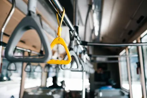 Selective focus of a yellow bus handle next to gray ones Photos