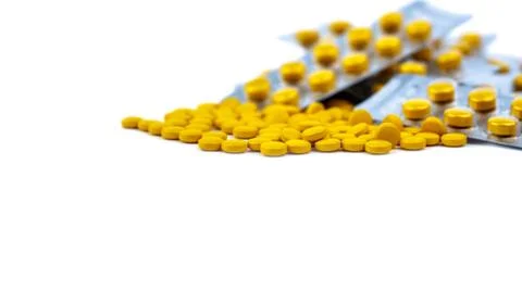 Selective focus on yellow tablets pill on blurred background of blister pack  Stock-Fotos