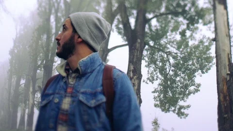 Selective focus on young bearded Caucasian man in stylish wear hiking in the 스톡 동영상 108730760
