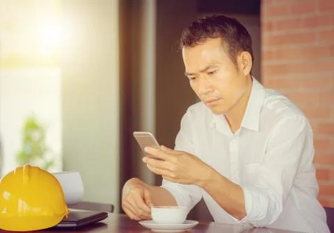 Selective focus of young business engineer man hand using mobile smart phone Stockfoto's