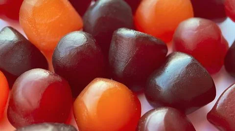 Selective focus.Close-up texture of red, orange and purple multivitamin gummies Stock Photos