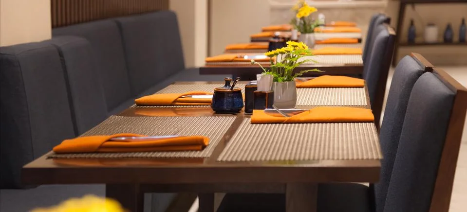 Selective Focused Empty Indoor Dining Tables, Place Mats, Cutlery and Napkin Stock Photos