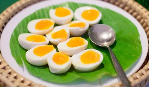 Selective Focused Halved Boiled Chicken Eggs served in green banana leaf tray Stock Photos
