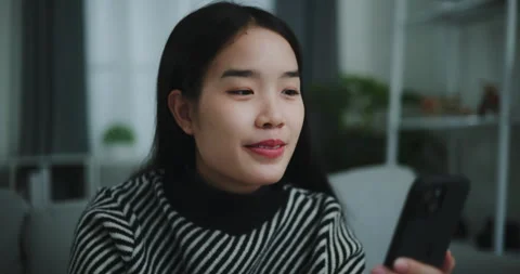 Selective focus,Face of Happy young asian woman sit on sofa holding coffee cup 스톡 동영상 263427176