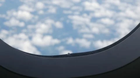 Selective focusing on airplane's window while plane is flying over white fl.. Stock Footage 296089663