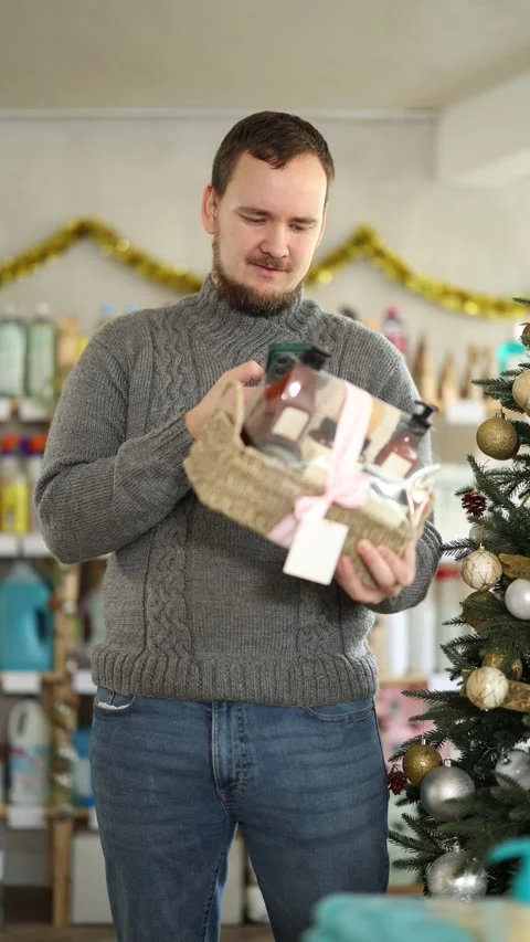 Selective middle-aged guy scanning barcode on gift basket in shop with New Year Stock Footage 321327059