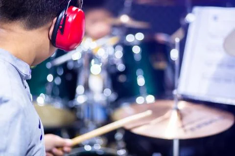 Selective to red ear muffs over head of musicians drummer with blurry the boy Stock Photos