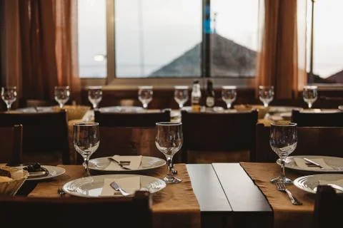 A selective shot of empty dishes and glasses arranged in a dining table of a  Stock Photos