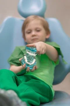 Selective soft focus. Child kid hands hold glass jaw with aching white teeth  Foto stock