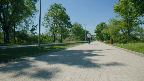 Self-balancing ride through park on electric one-wheeler Stock Footage 308656516