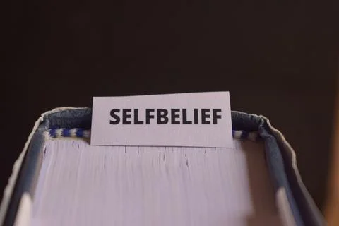 Self Belief Paper Tab Between Book Pages Symbolizing Confidence Building, M.. Fotos Stock