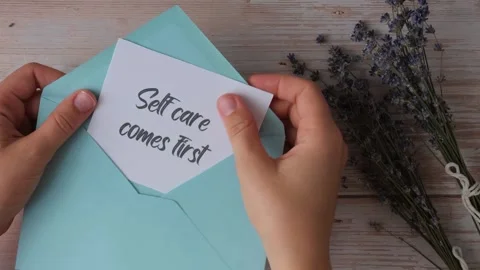 SELF CARE COMES FIRST text on supportive message paper note reminder from blue 스톡 동영상 264571288