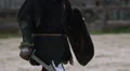 Self-confident knight in steel armor goes to fight arena with shield and sword HD Footage