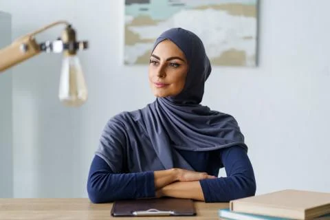 Self-confident lady sitting at the table with a distant look Stock Photos