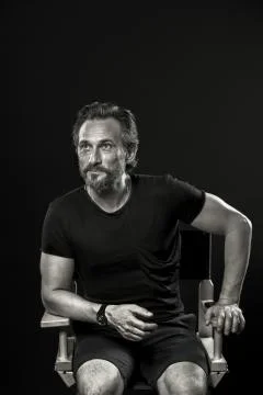Self confident man with cunning face sitting on chair. Stock Photos