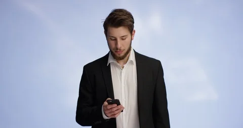 Self confident man is typing on his smartphone and starts smiling Stock Footage 98307372