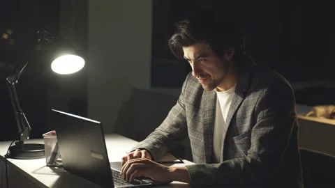 A self-confident programmer is a person who works at a computer at night. The Stock Footage 156653968