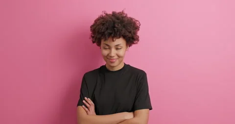 Self confident satisfied Afro American woman keeps arms folded looks directly at Stock Footage 150297592