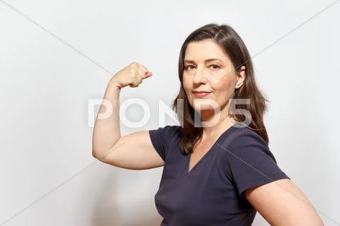 Self-confident woman flexing biceps muscles Stock Photos