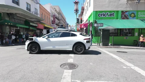 Self driving taxi driving on intersection. Tracking shot. San Francisco, USA. Stock Footage 282352453