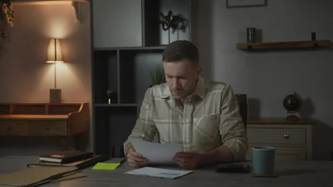 Self Employed Businessman Using Calculator While Reviewing Financial Printout Stock Footage 336748784