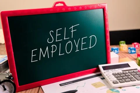 Self employed message on chalkboard with calculator nearby Stock Photos