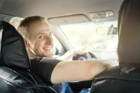 Self-employed russian smiling driver in his car taxis or works on delivery Stock Photos
