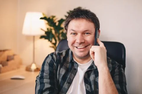 Self-employed young man posing for the camera in his home office, smiling and Stock Photos