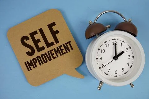 Self Improvement text with alarm clock on blue background Stock Photos