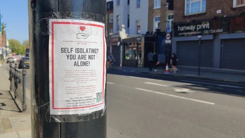 SELF-ISOLATING? YOU ARE NOT ALONE SIGN AND PEOPLE EXERCISE DURING COVID-19 Stock Footage 128689903