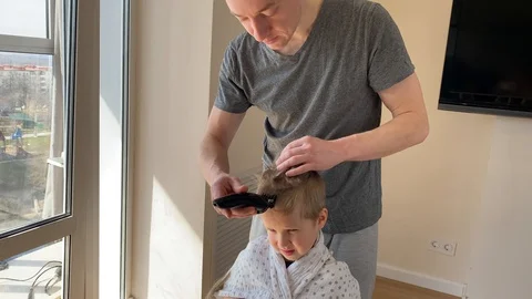 Self-isolation concept. Father cutting the hair of a little son Stock Footage 129147242