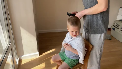 Self-isolation concept. Father cutting the hair of a little son with a hair  Stock Footage 129147339