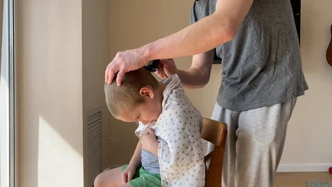 Self-isolation concept. Father cutting the hair of a little son with a hair Stock Footage 129148833