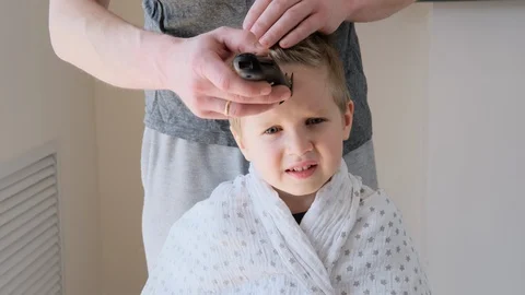 Self-isolation concept. Father cutting the hair of a little son with a hair Video stock 129149253