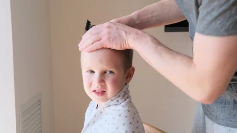 Self-isolation concept. Father cutting the hair of a little son with a hair Stock Footage 129149481