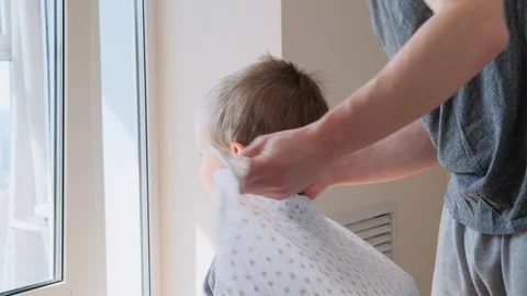 Self-isolation concept. Father cutting the hair of a little son with a hair Stock Footage 129150422