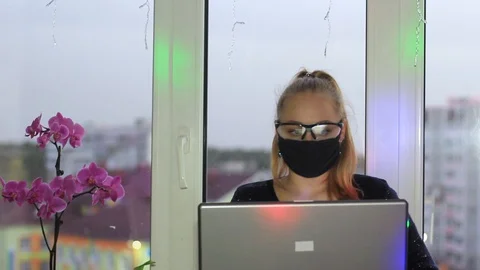 Self-isolation freelancer girl working on a laptop during an epidemic. The Stock Footage 128952410