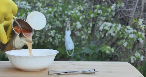 Self-isolation. A man puts canned beans on a plate. Video stock 130087050