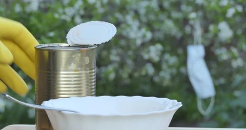 Self-isolation. A man puts canned beans on a plate. Video stock 130087074