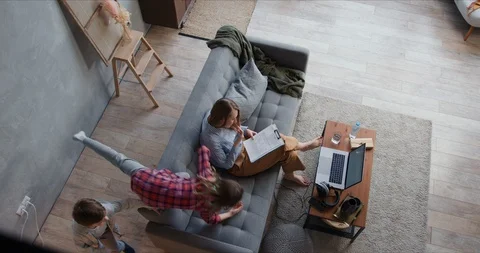 Self isolation. Top view tired mother trying to work from home using laptop Video stock 129081089