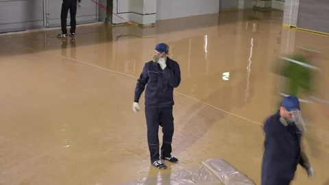 Self-leveling floor in the workshop. Builders make a self-leveling floor in the Stock Footage 317166802