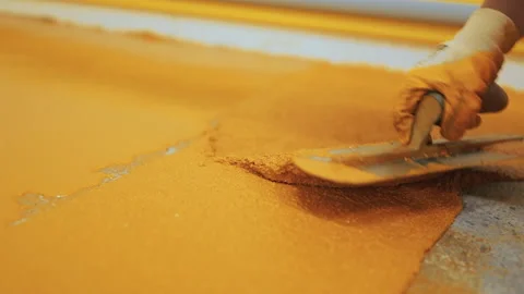 Self-Leveling Floors on a large industrial hall, A worker pours and apply the Stock Footage 161475264