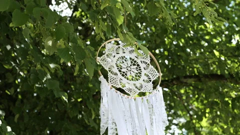Self-made dream catcher with white fabric handing in a tree on a wedding party. Video stock 197482123