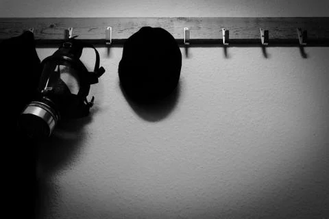 Self-made wardrobe with a flat cap, gas mask and coat hanging Foto stock