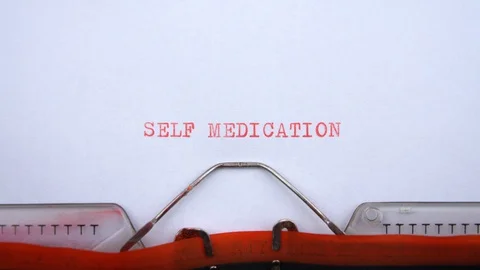Self medication - phrase printed on an old typewriter in red letters, close up. Video stock 128399445