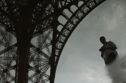 Self-portrait under the Eiffel Tower reflected in a puddle Stock-Fotos