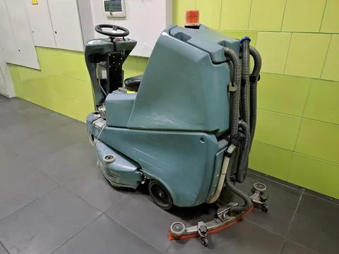 Self-propelled floor scrubber with operator seat. Ride-on floor scrubber machine Stock-Fotos