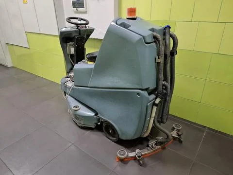Self-propelled floor scrubber with operator seat. Ride-on floor scrubber machine Stock-Fotos