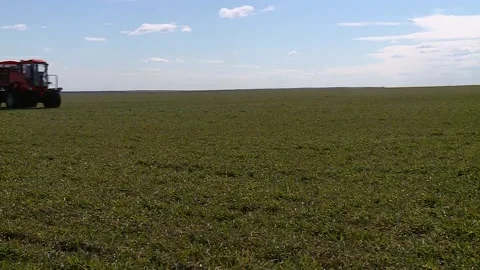 Self propelled sprayer fertilizer spreader rides on a green field Stock Footage 130269238